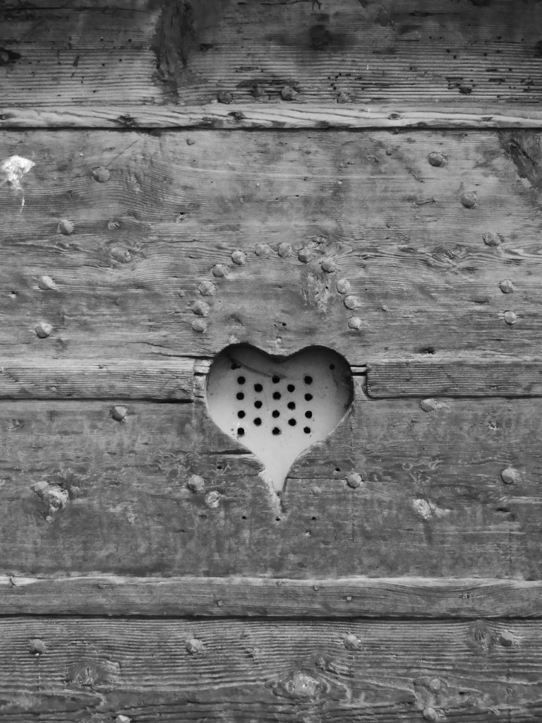 Porte en bois cloutée et ajourée d'un judas en forme de coeur